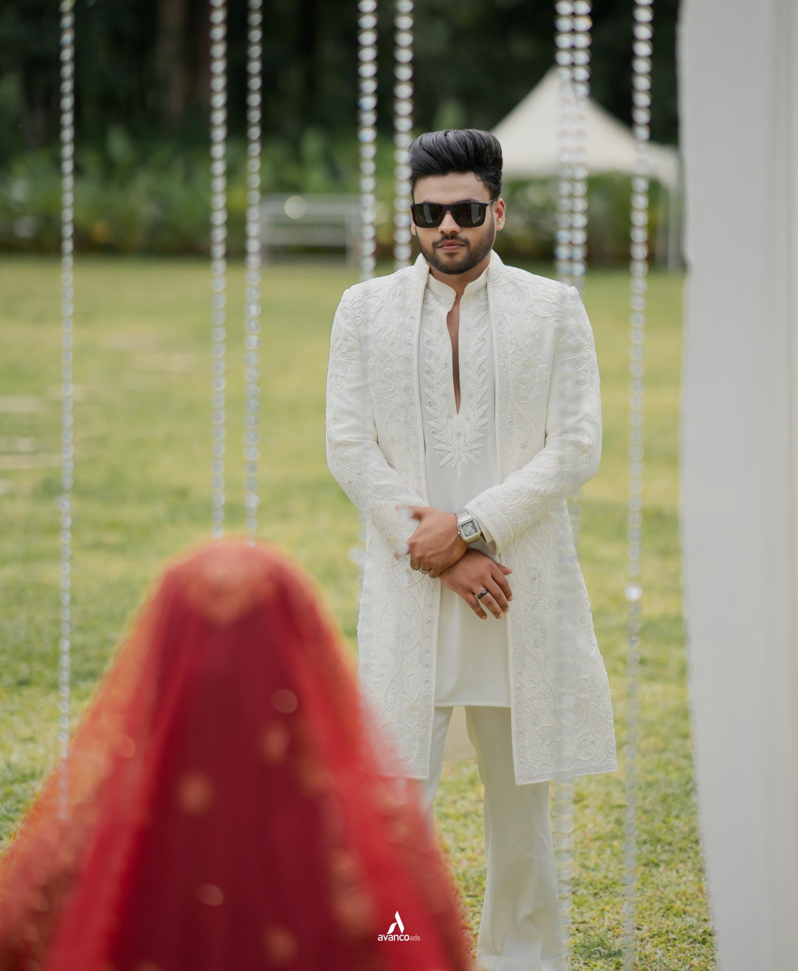 A groom facing his bride during an outdoor ceremony